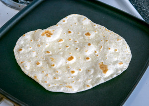 homemade flour tortilla after one side cooked