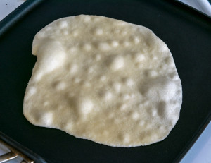 homemade flour tortilla bubbling on comal