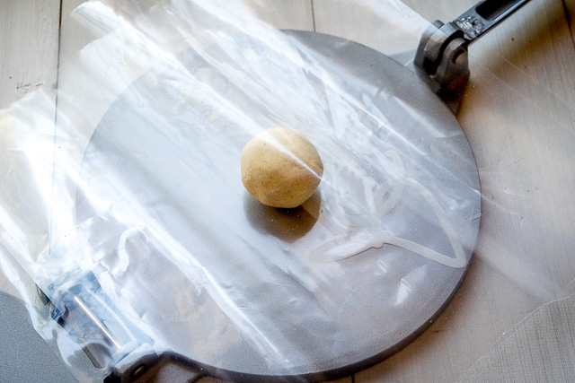 Putting a masa dough ball in a tortilla press