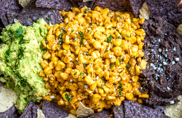 Mexican Street Corn is typically slathered in a creamy Chili-Lime sauce. This recipe adds beans and guacamole to the mix and the result is a meal worthy dip that is delicious! mexicanplease.com