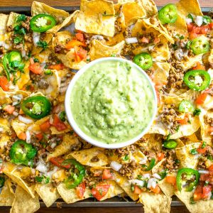 These Spicy Ground Beef Nachos have the potential to save your day. Chipotles w adobo dają wołowinie prawdziwego kopa, a po nałożeniu na chipsy tortilla pokryte serem szybko stają się posiłkiem typu go-to. Podawane z domową Salsą Verde z awokado i dodatkami do wyboru. So good! mexicanplease.com