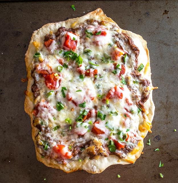 This Spicy Black Bean Pizza relies on a delicious black bean puree and a thin layer of garlic oil to create a vegetarian delight. So good! mexicanplease.com 