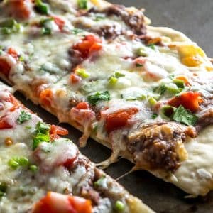 A crispy, thin crust pizza that relies on a delicious black bean puree and a thin layer of garlic oil to create a vegetarian delight. So good! mexicanplease.com