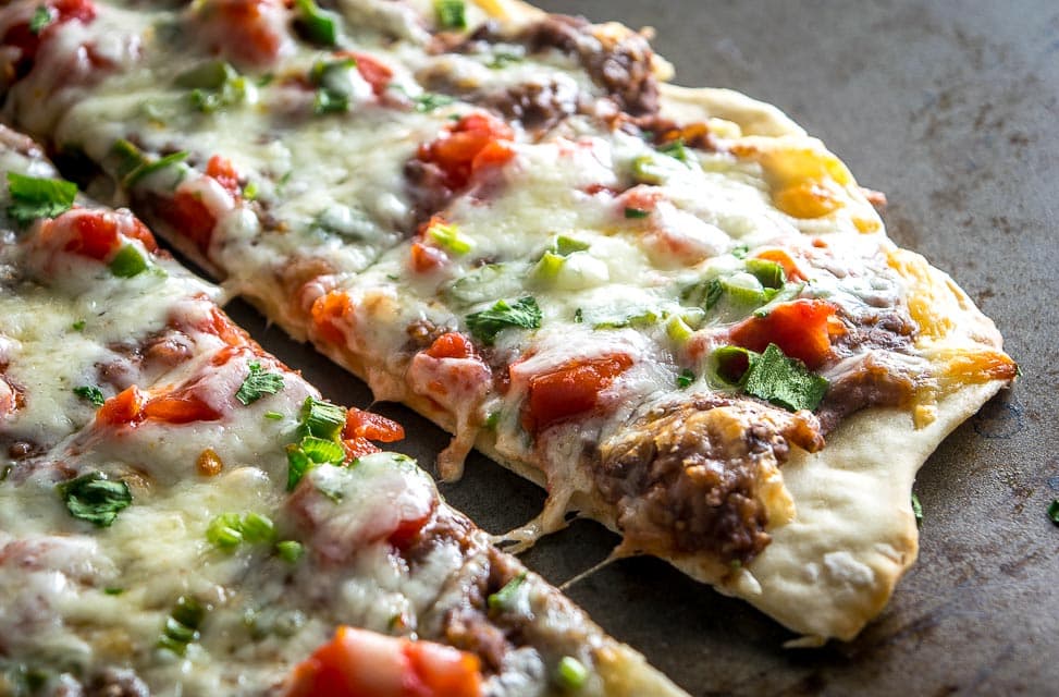 A crispy, thin crust pizza that relies on a delicious black bean puree and a thin layer of garlic oil to create a vegetarian delight. So good! mexicanplease.com