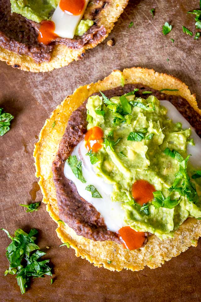 Serious reward to effort ratio in these tostadas! We're crisping a corn tortilla and loading it up with spicy black bean puree and a refreshing guacamole. So good! mexicanplease.com