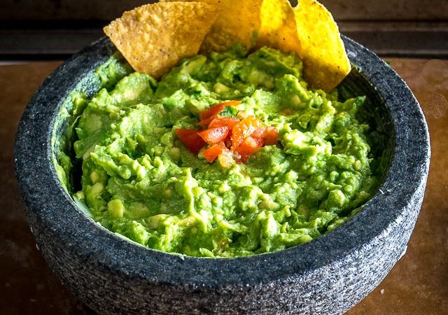 We're grinding an onion-jalapeno-cilantro paste in a molcajete for a delicious batch of homemade guacamole. Don't forget a final squeeze of lime, so good! mexicanplease.com