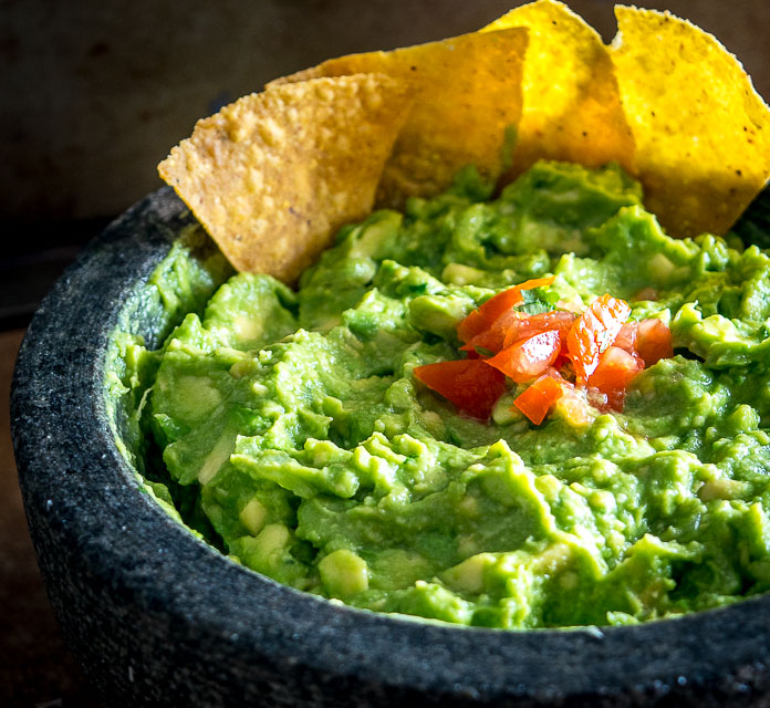 We're grinding an onion-jalapeno-cilantro paste in a molcajete for a delicious batch of homemade guacamole. Don't forget a final squeeze of lime, so good! mexicanplease.com