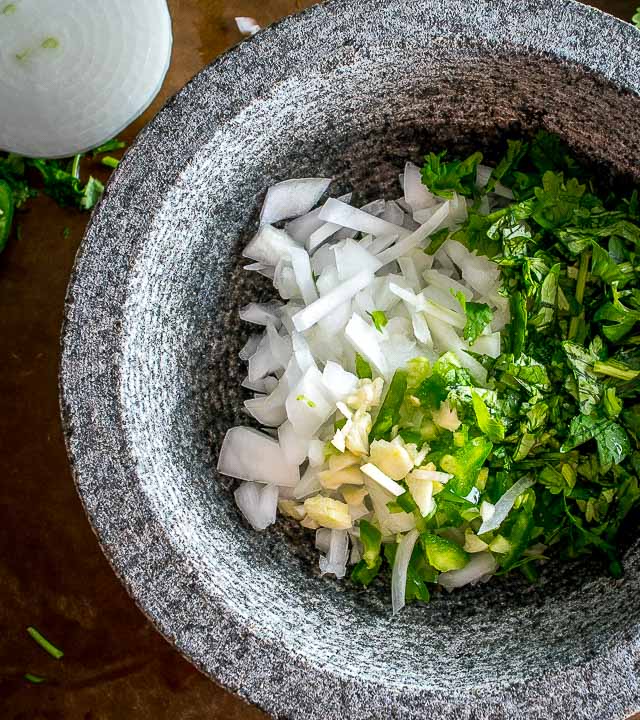 The flavor you can generate by smooshing ingredients in a molcajete is unreal. You'll end up with a vibrant batch of Salsa Verde that could potentially cause you to break up with the other salsas in your life. mexicanplease.com 