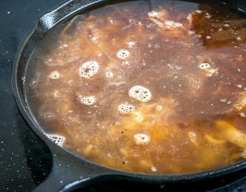 simmering broth in caramelized onions
