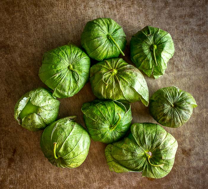 fresh tomatillos on cutting board