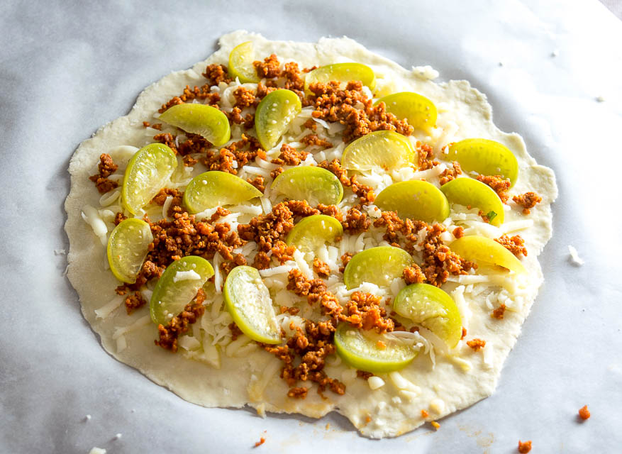 This is my new favorite pizza! The pickled tomatillos pair well with the chorizo and we're using a garlic oil layer as the sauce -- so good! mexicanplease.com