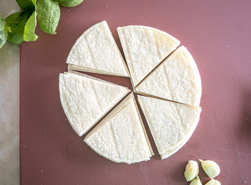 cutting corn tortillas into pieces for frying