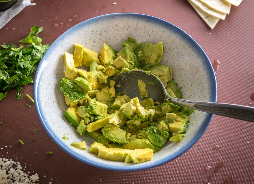 Tossing the avocado with lime and salt.