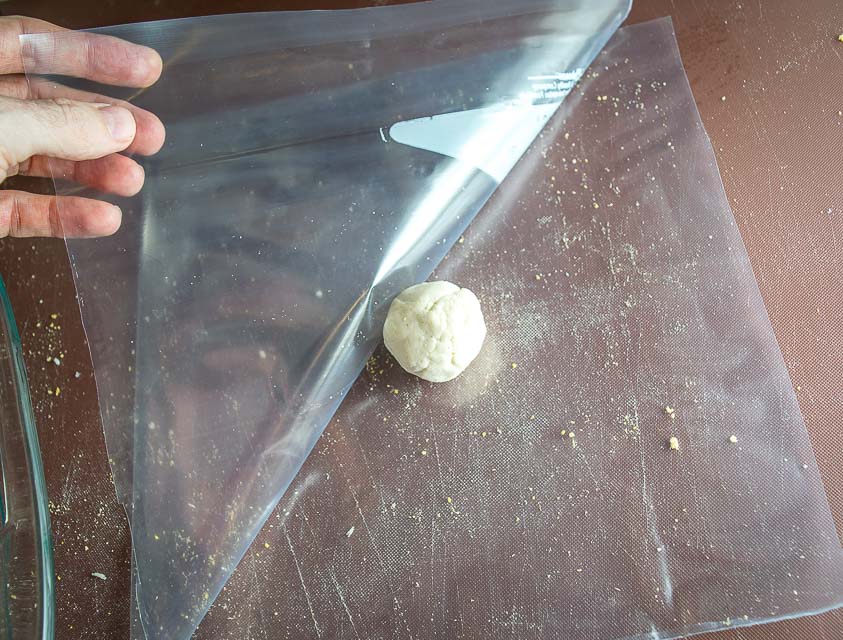 Placing dough ball between ziploc sides. 