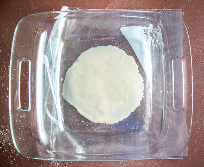 Using casserole dish to flatten dough balls.