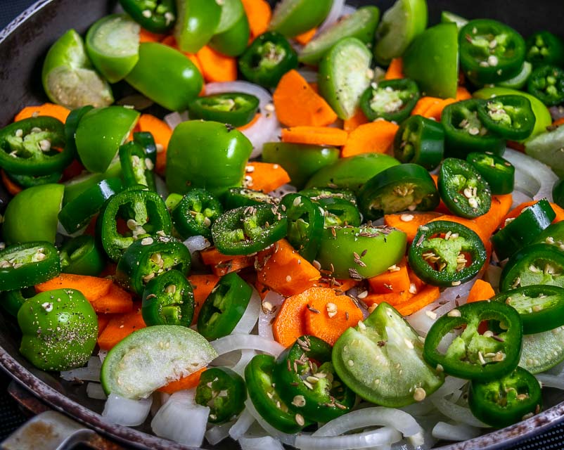 Adding chopped jalapenos and tomatillos.