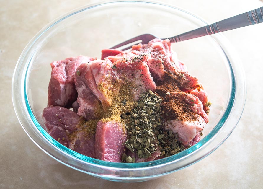 Seasoning the Carnitas with Mexican oregano