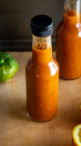 Putting hot sauce in two 5 oz. bottles