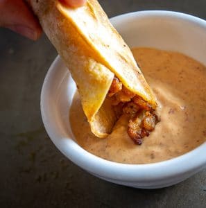 Dipping taquito in Chipotle Mayo