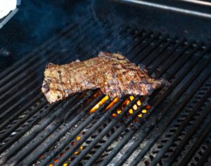 Charring skirt steak on the grill for Carne Asada