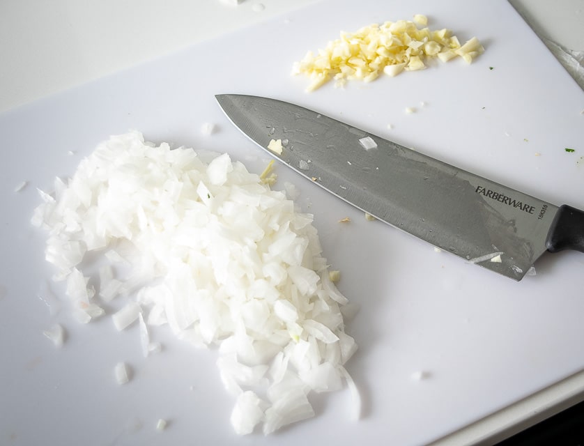 Chopping up onion and garlic for Queso Dip