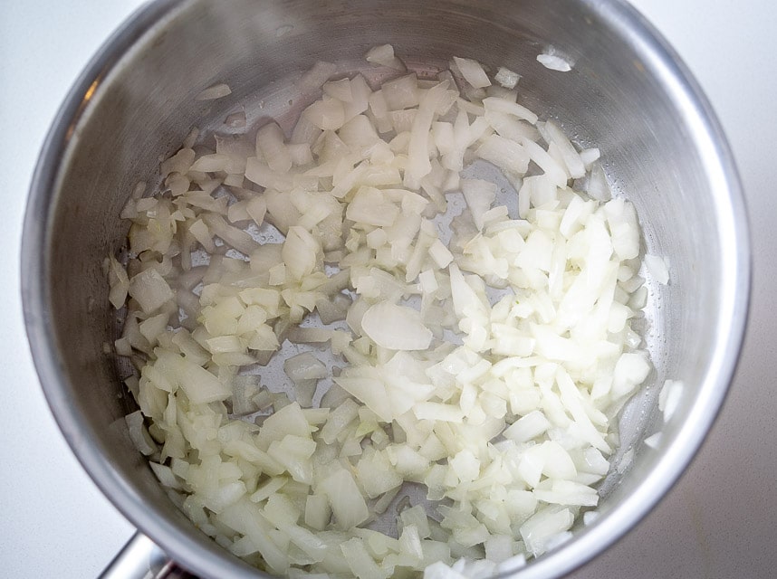 Adding onion and garlic to saucepan