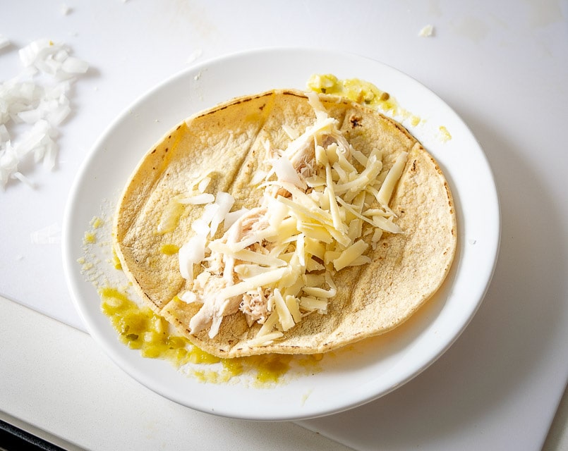 Building the Hatch enchiladas with chicken, cheese, and onion. 