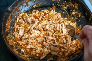 Combining 1/2 cup Tinga sauce with shredded chicken