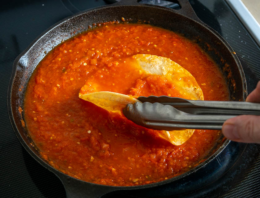 Coating tortillas with the Entomatada sauce