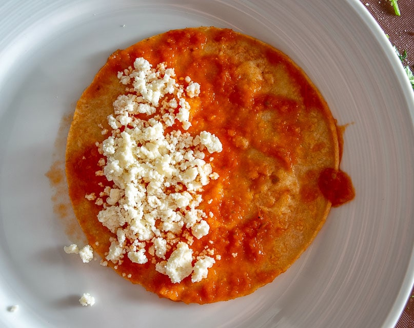 Adding Queso Fresco to the corn tortillas