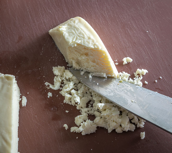 Using knife to crumble Queso Fresco
