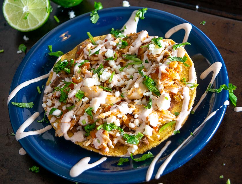 Adding Queso Fresco and Crema to the tostada