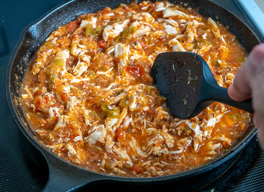 Adding shredded chicken to the Tinga sauce