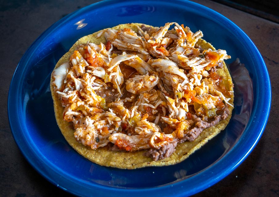 Adding Tinga de Pollo to the tostada