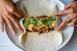Using fingers to fold burrito ends