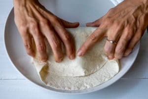 Tucking tortilla in tight around the fillings