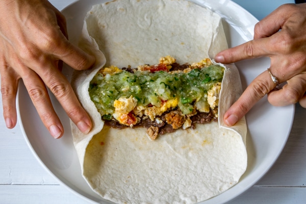 Step 3:  Pull up the sides of the tortilla and lightly hold them in place with your fingers.