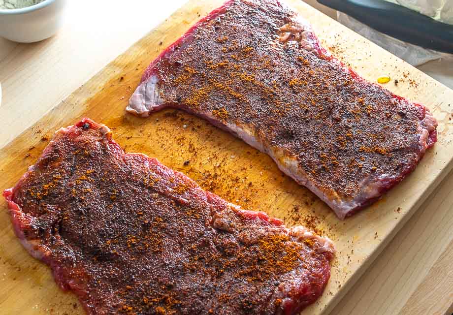 Adding dry spice rub to the skirt steak