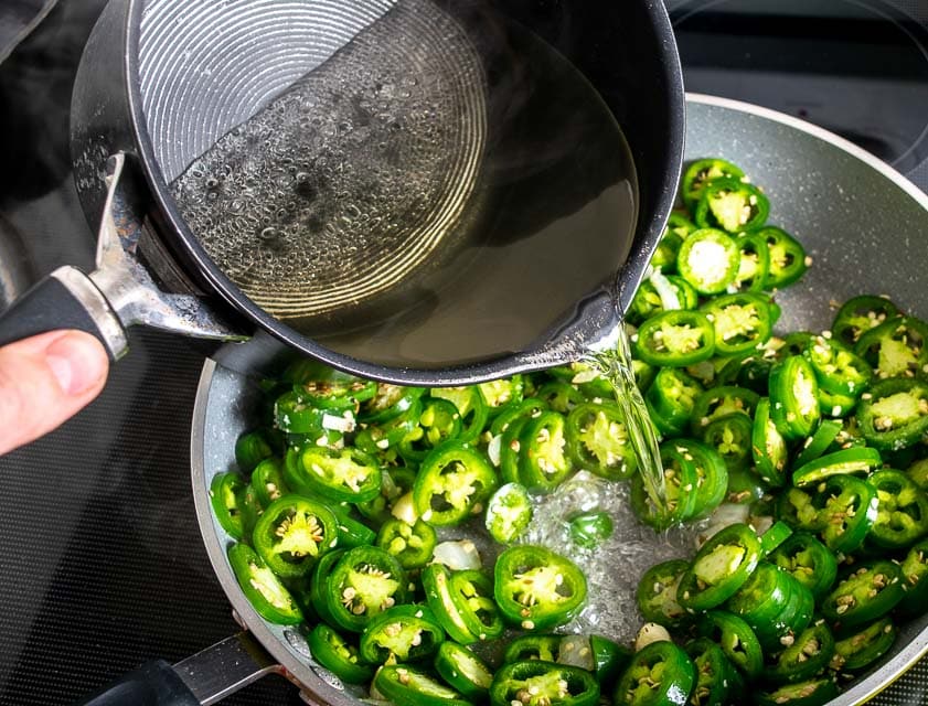 Adding the sugar vinegar mixture to the jalapenos