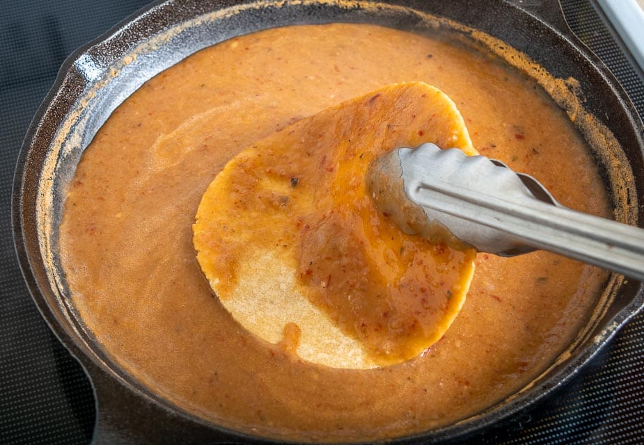 Dipping corn tortillas in the Enfrijoladas