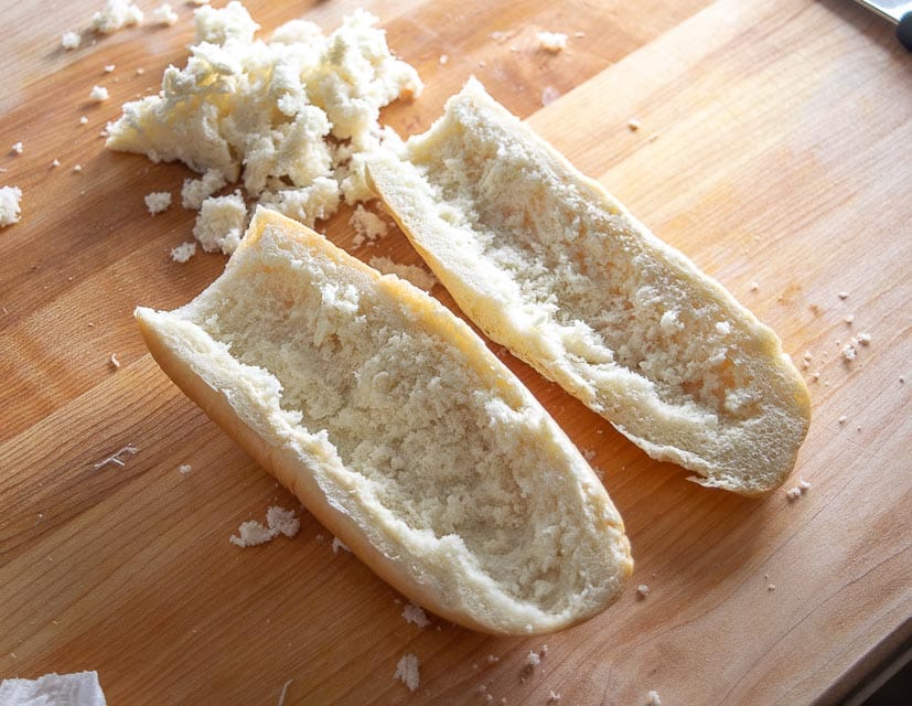 Pulling out inner chunks of bread from the rolls