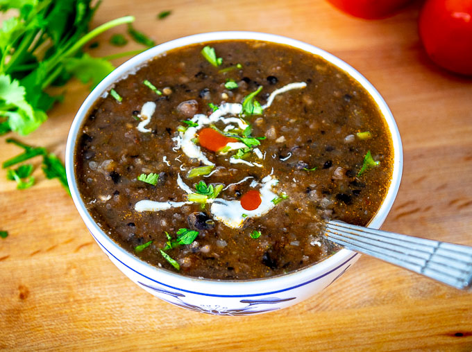 Bean soup topped with Mexican Crema, cilantro stems, and a squeeze of lime