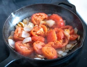 Adding roasted tomatoes to the onion and garlic