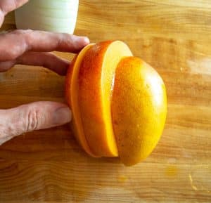 Cutting a fresh mango into three parts