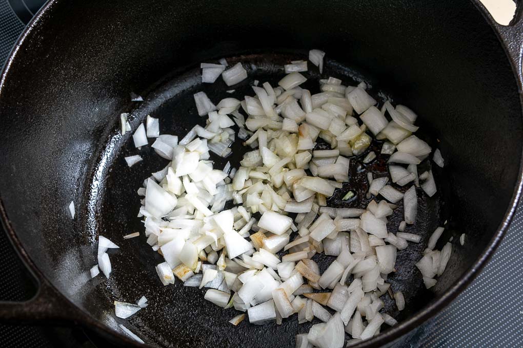 koken fijn gesneden ui en knoflook voor de Calabacitas