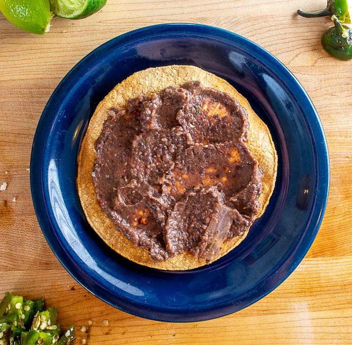 Adding refried beans to a homebaked tostada shell