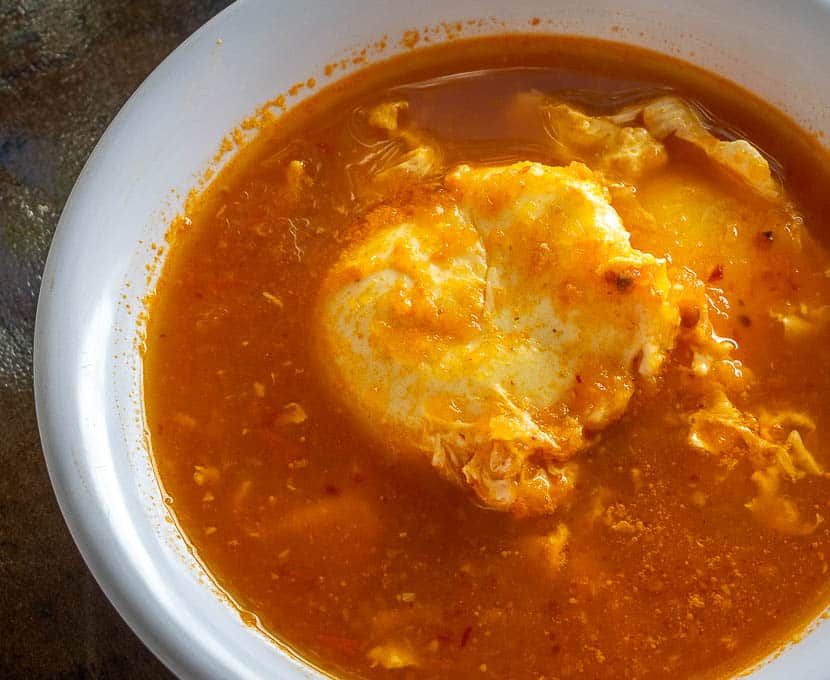 Poached egg resting in salsa broth