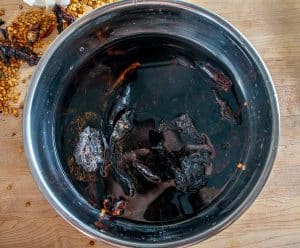 Letting the dried chiles reconstitute in hot tap water