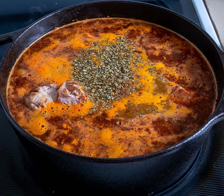 Adding spices to the Pozole before simmering