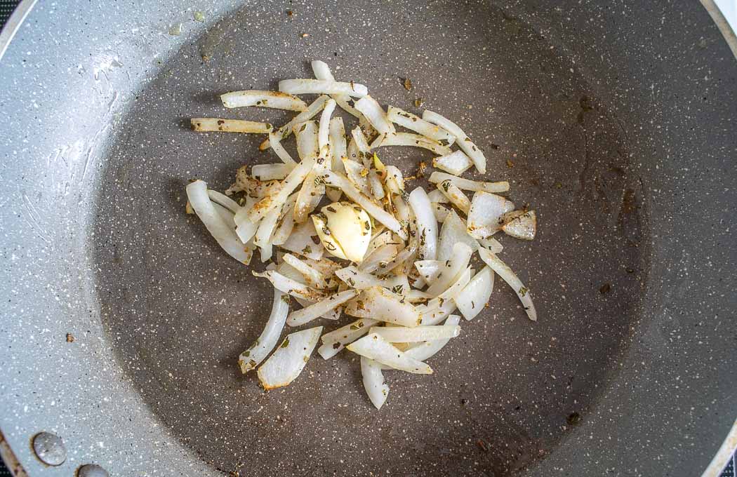 Adding spices and Mexican oregano to the pan